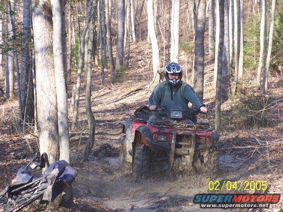 2003 Honda RUBICON ATV riding through mud on a wooded trail