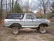 1979 Ford Bronco - This lifted 1979 Ford Bronco features a two-tone paint scheme with a silver body and black hardtop, modified for off-road use.