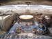 1979 Ford Bronco - The engine bay of an older vehicle is shown, a V8 engine with a prominent air filter and carburetor.