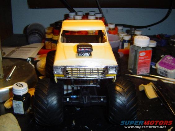 Yellow 1979 Ford Bronco model monster truck with large tires and scoop on hood