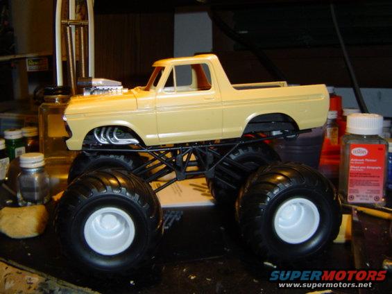 Yellow model monster truck with large tires and exposed engine