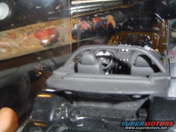 Black toy car interior with dashboard and seats visible