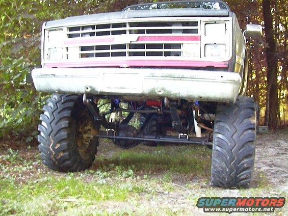 Front view of a lifted pickup truck with large tires and a prominent grille