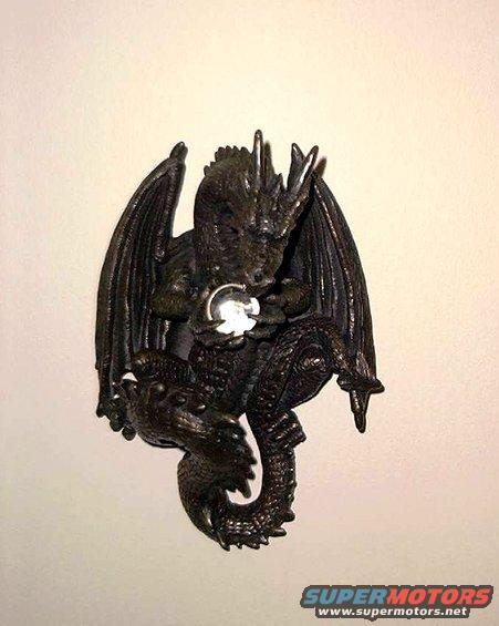 Dark dragon figurine holding a clear orb, mounted on a wall