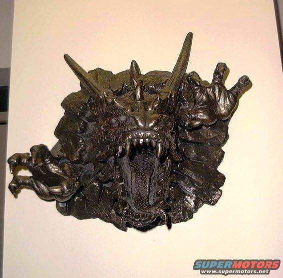 Bronze dragon head sculpture with open mouth and sharp teeth