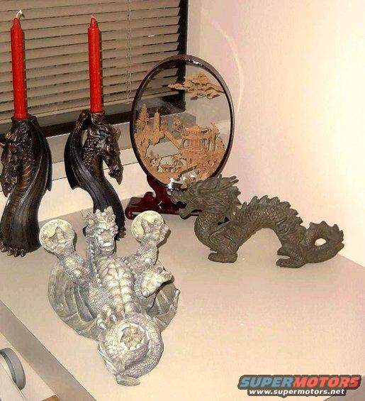 Dragon statues and red candles on a shelf