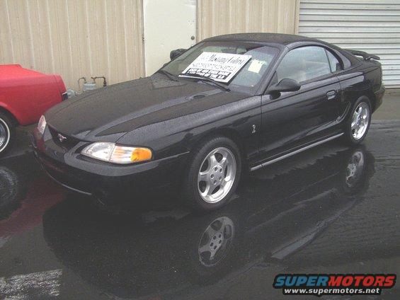 Black 2002 Ford Mustang coupe with spoiler and aftermarket wheels