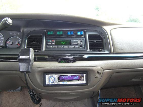 Car interior dashboard with aftermarket stereo, radio, and microphone. Clock shows 6:23