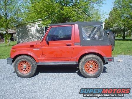 red Suzuki Samurai parked on gravel, soft top up, spare tire on back