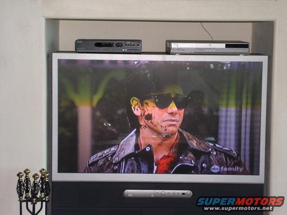 TV screen shows man with sunglasses and blood splatters on face