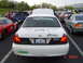 1999 Ford Crown Victoria - A white 1999 Ford Crown Victoria is parked with its hood open, showing other vehicles in the background.