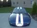 1995 Ford Probe - A blue 1995 Ford Probe with white racing stripes is parked in front of a brick building.