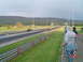 1999 Ford Crown Victoria - Two cars compete on a drag strip under a cloudy sky, with a mountain range in the background.
