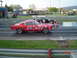 1999 Ford Crown Victoria - Two race cars, a classic Mustang and a modern Porsche, line up on a drag strip for a race.