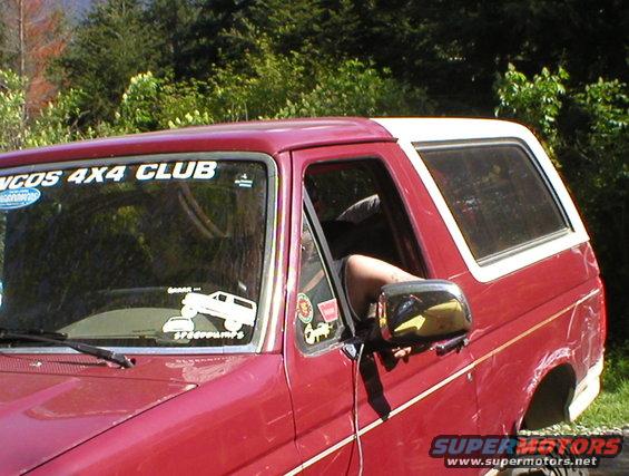 Red Bronco with white top, "Broncos 4x4 Club" sticker on windshield