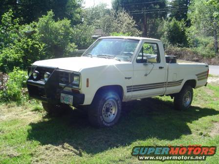 White 1988 Ford Ranger pickup truck with a bull bar and auxiliary lights, parked on grass