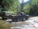 1988 Ford Ranger - Two trucks are driving through a stream in a wooded area.
