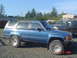 1988 Ford Ranger - This blue SUV with a camper shell is parked next to a dark pickup truck.