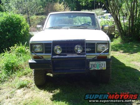 Front view of a white 1988 Ford Ranger pickup truck with a black bull bar and auxiliary lights