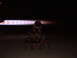1988 Ford Bronco - A group of people form a pyramid in front of a powerful jet exhaust at night.