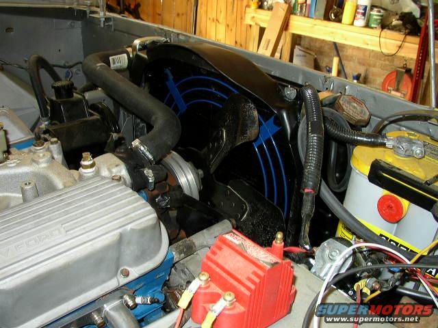 Engine bay showing fan shroud, battery, and valve cover with "FORD" visible