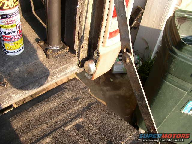 1995 Ford Bronco tailgate interior, showing a can of penetrating oil and a metal bracket