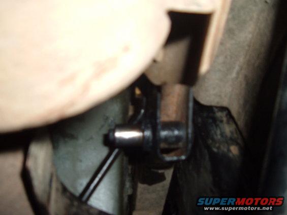 Close-up of a metal bracket and bolt on a vehicle's undercarriage