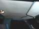 1982 Ford Bronco - The interior ceiling of a vehicle shows a dome light and two sun visors.