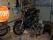1976 Harley-Davidson Super Glide - A motorcycle is elevated on a lift in a garage, surrounded by tools and cleaning supplies.