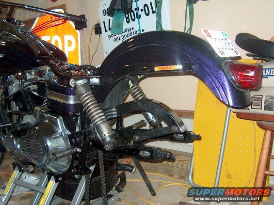 Purple motorcycle rear fender and engine on a stand