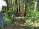 1993 Ford Bronco - A red pickup truck from the 1980s is seen abandoned in a wooded area, with a man visible in its bed.