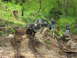 1993 Ford Bronco - Off-road vehicle navigates a challenging muddy terrain with onlookers present.
