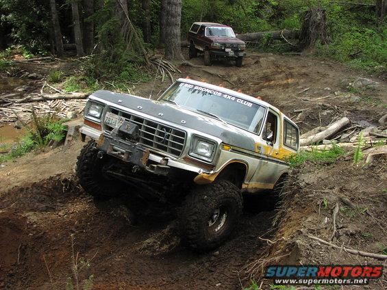 Ford Bronco with lifted suspension and large tires navigating a muddy trail