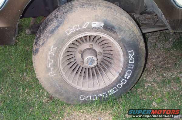 Close-up of a dirty Michelin tire with white lettering on a vehicle's wheel