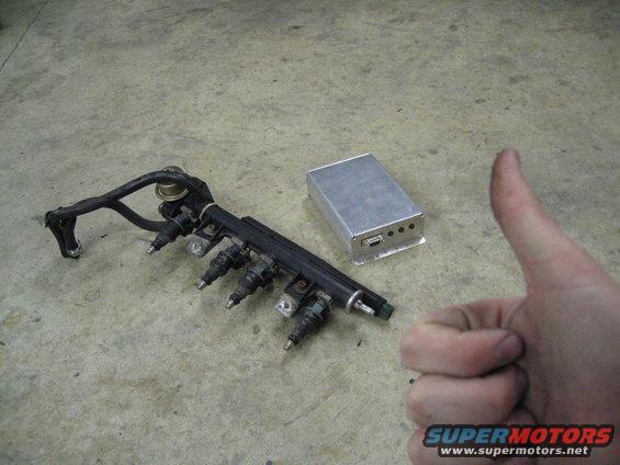Fuel rail with four injectors and a silver metal box with ports