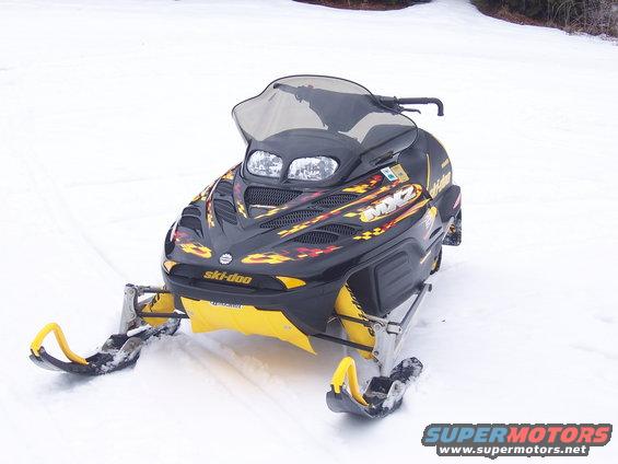 Black Ski-Doo MX Z 500 Sport snowmobile with yellow accents and flame graphics, viewed from the front in the snow