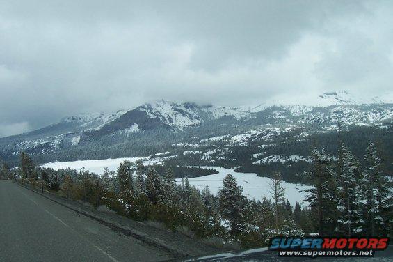 Snowy mountains and a frozen lake seen from a road