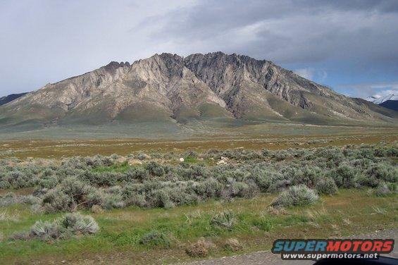 Mountain landscape with sagebrush in foreground and cloudy sky