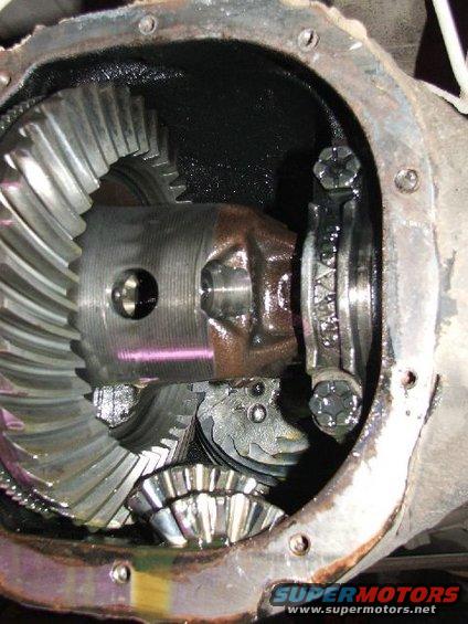 Close-up of differential gears inside a housing, showing a large ring gear and smaller spider gears