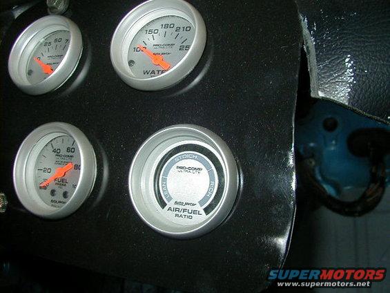 Dashboard with four Pro-Comp gauges: water temperature, fuel pressure, and air/fuel ratio. The panel is black and shows some wear