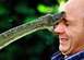 1990 Ford Bronco - A snake's head is pressed against a man's forehead, with its mouth open. The man appears startled.
