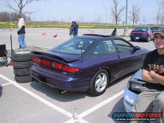 Purple 1993 Ford Probe with racing number 125 on the rear window, parked in a lot with cones