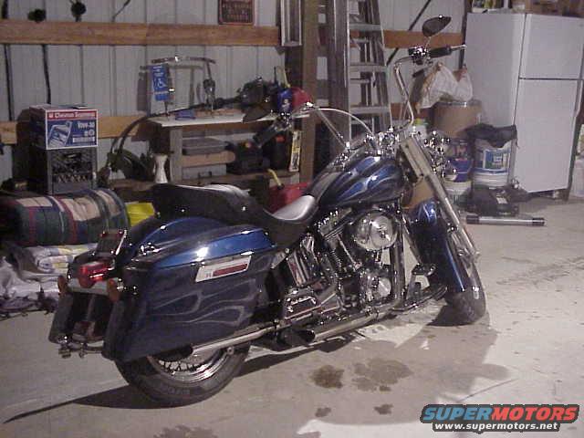 Blue motorcycle with flame decals parked in a garage