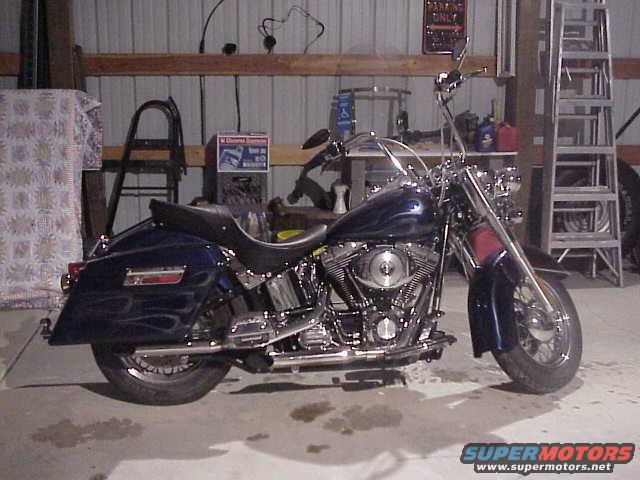 Blue Harley-Davidson motorcycle with flame decals parked in a garage