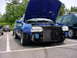 1998 Volkswagen Jetta - A blue car with its hood open, revealing the engine bay and radiator. The vehicle is parked in a lot with other cars visible.