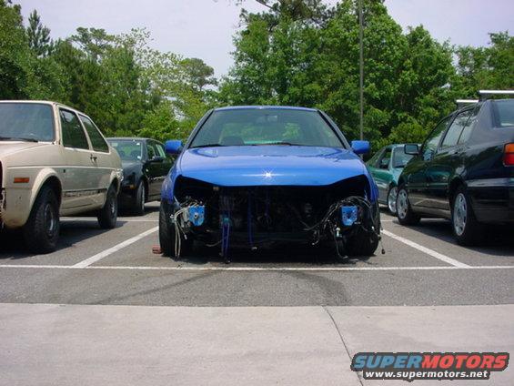 Blue 1998 Volkswagen Jetta with front bumper and grille removed, parked next to other cars