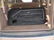 1978 Ford Mustang II - A black door panel a chrome trim accent and a horse emblem, consistent with a 1978 Ford Mustang II, is stored in the cargo area of another…
