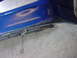1998 Volkswagen Jetta - Close-up of a damaged blue bumper, revealing rust and the underlying metal support.
