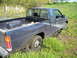 1979 Ford F-150 - A black pickup truck is stuck in the mud next to a body of water with tall grass.