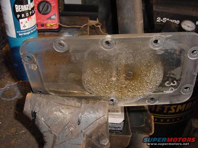 Clear plastic part with visible "39" marking, held in a vise